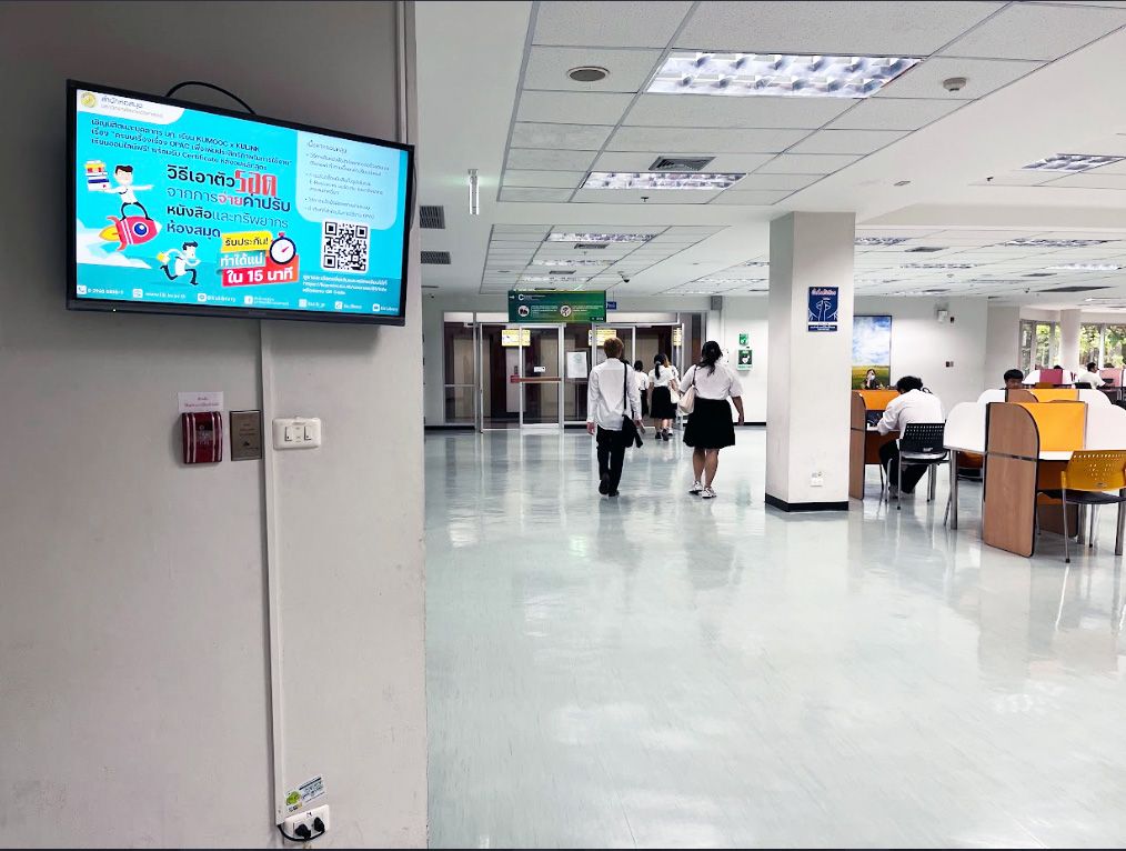 Digital signage screen in an elevator lobby at Kasetsart University Library